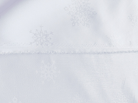 Wyjątkowa dwustronna tkanina obrusowa z brokatowym srebrnym połyskiem i plamoodporną powłoką.