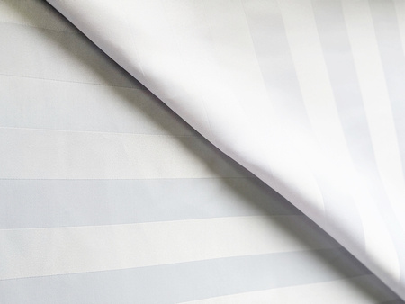 Tkanina plamoodporna biała w satynowe pasy o szerokości 5 cm.